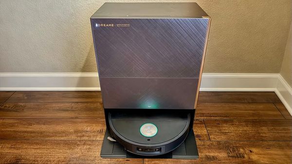 Dreame X60 Max Ultra Complete robot vacuum in its rectangular dock on a wood floor against a beige wall.