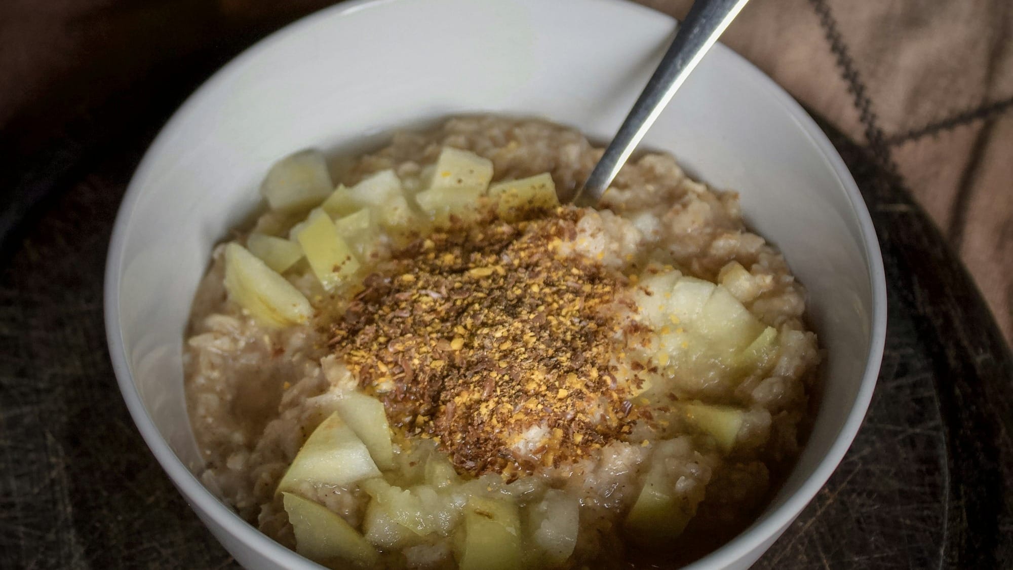 bowl of oatmeal topped with chopped green apples