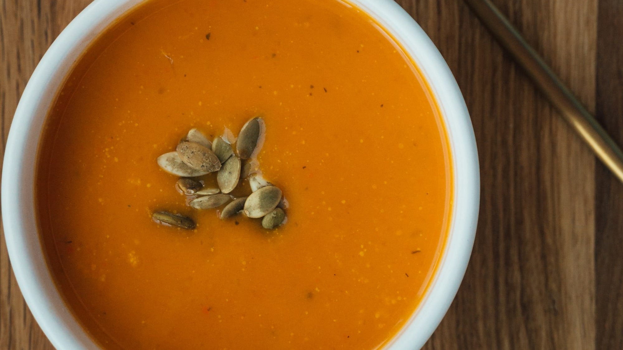 brown wooden spoon with orange soup