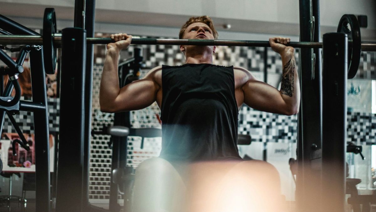 Bodybuilder shoulder pressing weight.