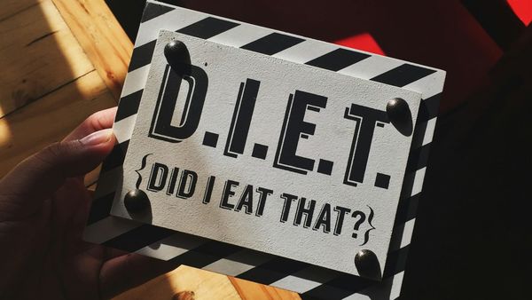Person holding up a sign saying DIET did it eat that.