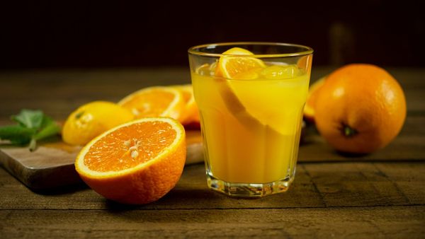 Table with orange and orange juice on it.