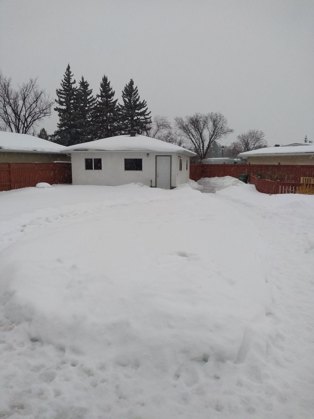 Backyard and garage covered in snow.