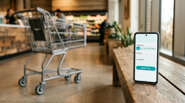 Empty shopping cart abandoned next to a smartphone displaying an unfinished nonprofit donation form