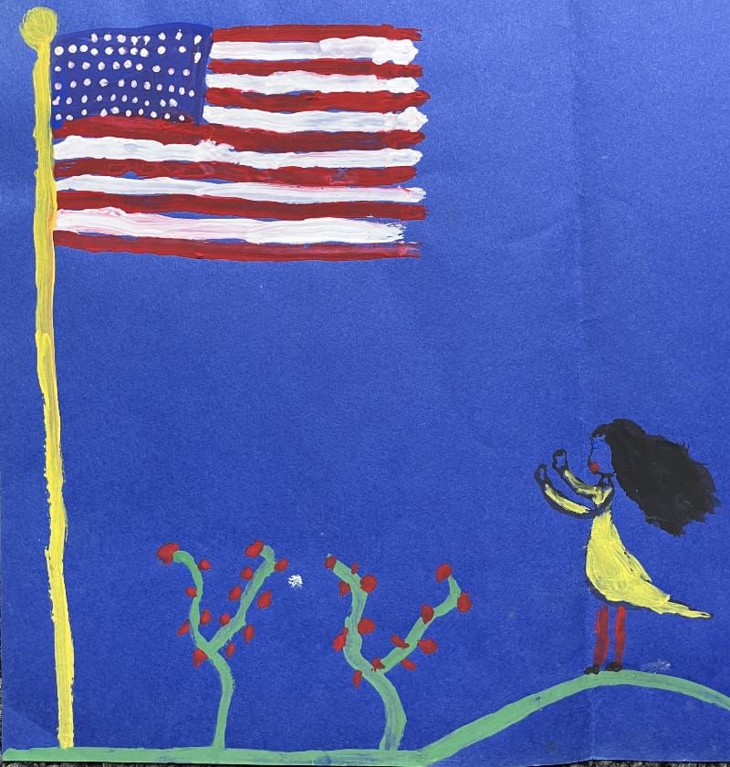 Girl in yellow dress  with black hair looks up to the US flag. Bushes with red fruit stand by.