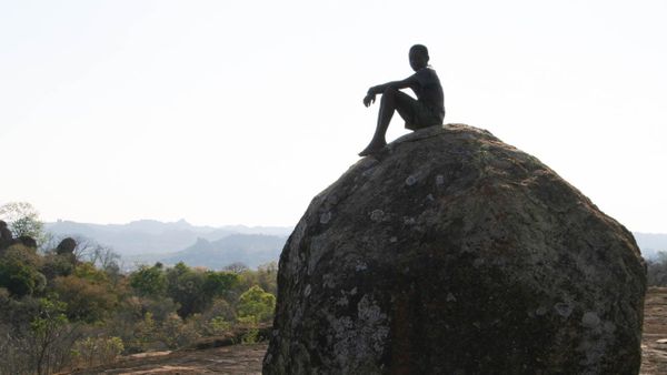 a child sitting on a large boulder, Matopo Hills in Zimbabwe