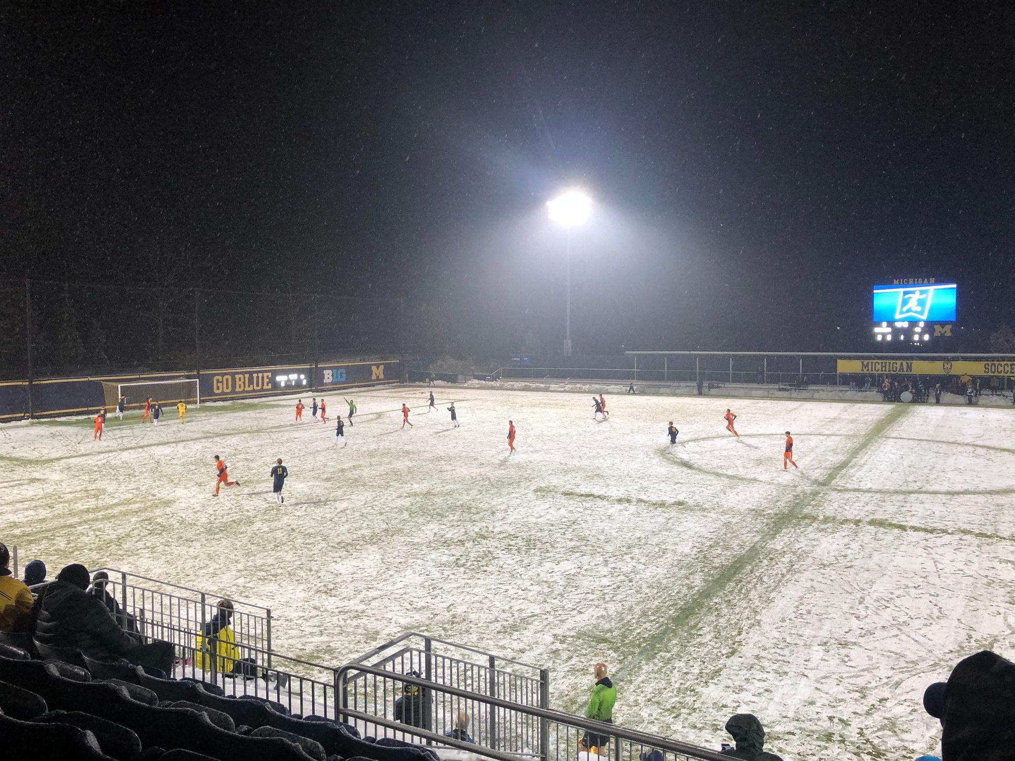 The University of Michigan and Princeton play men's soccer on a snowy field.