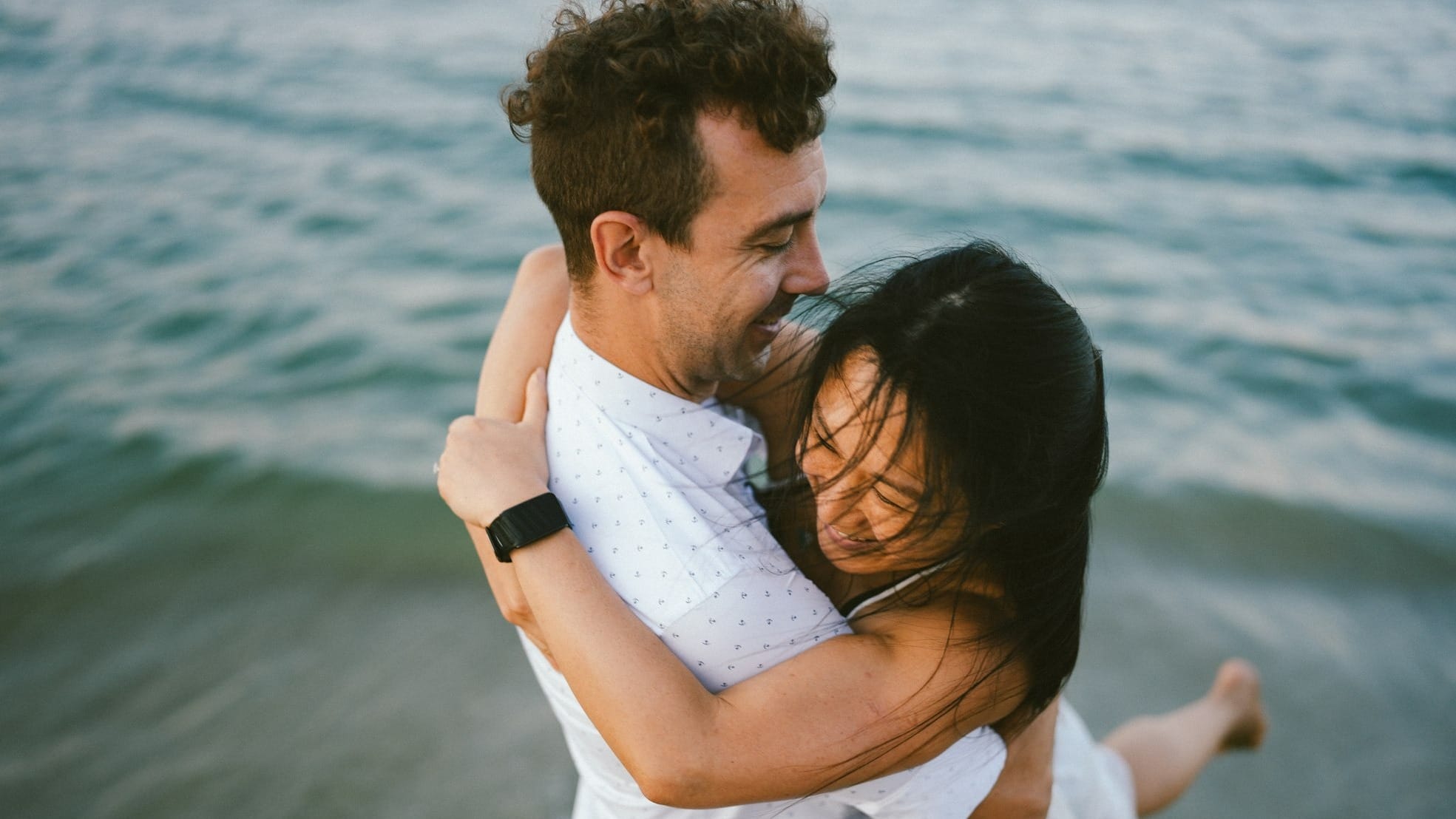 Couple embracing on the beach near the ocean