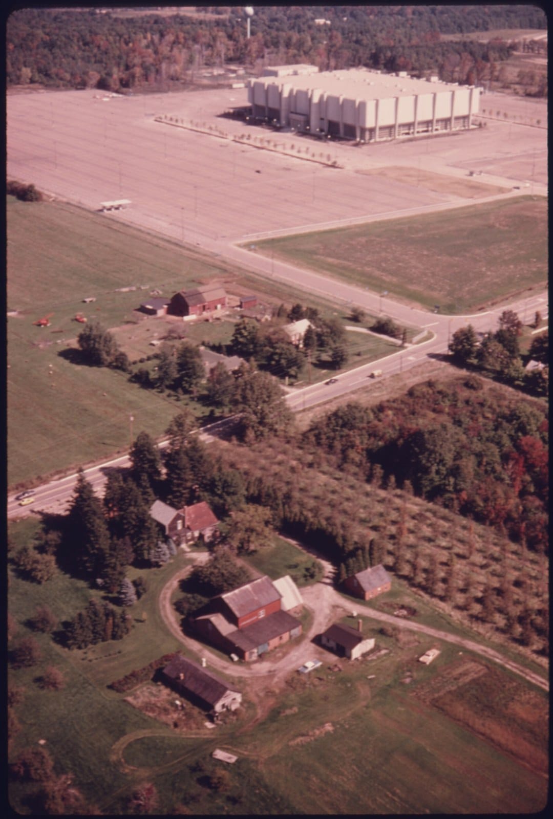 The Coliseum alone in the farmland — the population-center bet, visible from the air