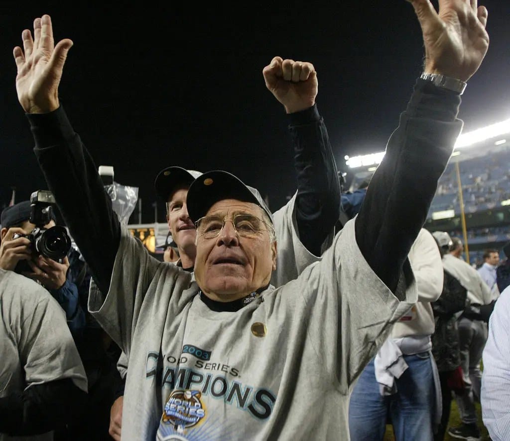 McKeon, 73 by the parade, arms up in Yankee Stadium.