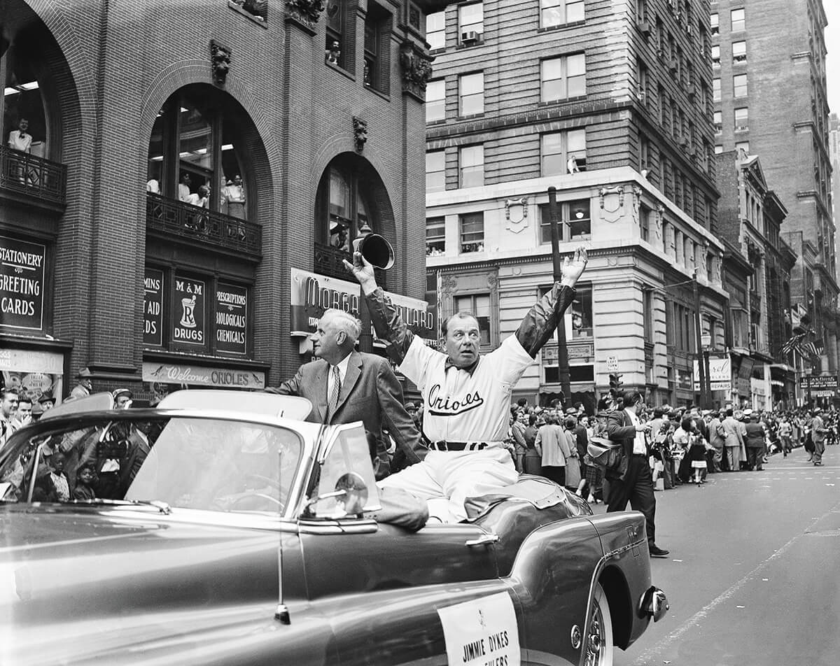 April 15, 1954: manager Jimmy Dykes waves from a convertible in the downtown Baltimore parade before the Orioles' first game.