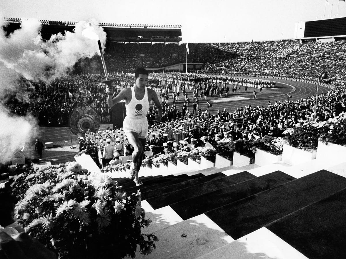 Yoshinori Sakai runs the Olympic flame up to the cauldron at the National Stadium, Oct. 10, 1964.