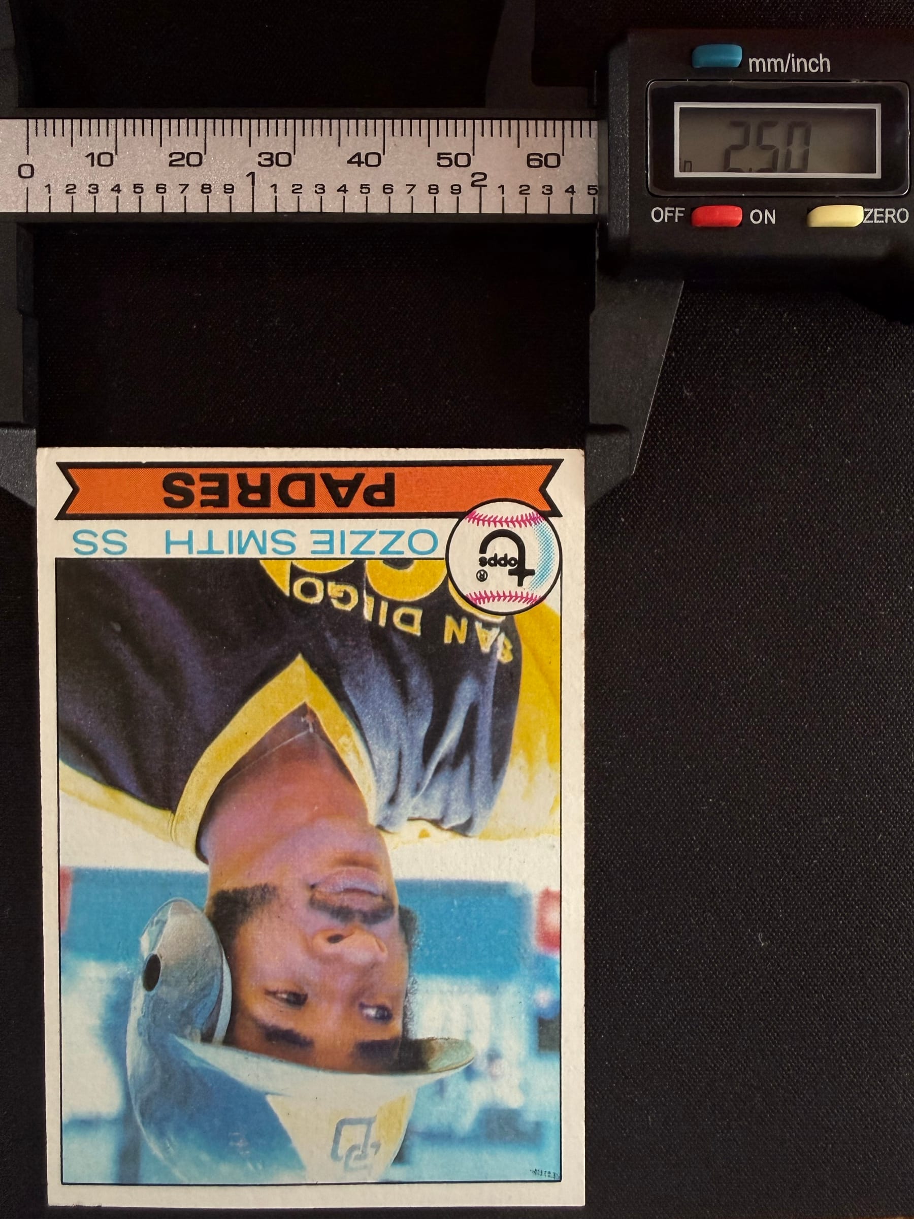 Calipers set to 2.50 inches, the width of a standard card, next to a 1979 Topps Ozzie Smith rookie.