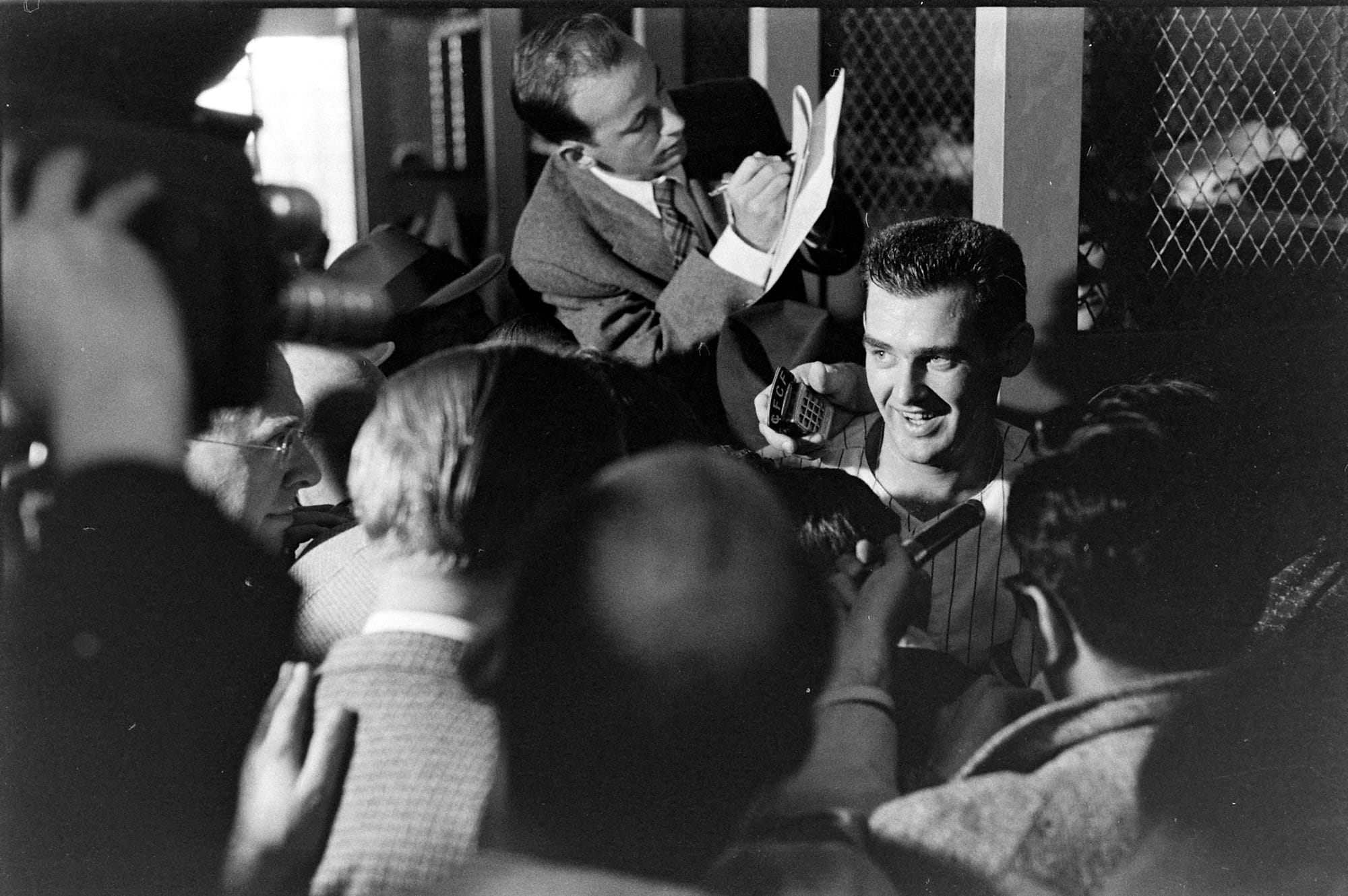 Larsen surrounded by reporters and microphones in the Yankee clubhouse.