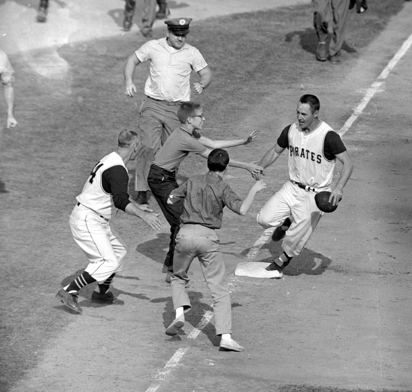 Fans join Mazeroski as he rounds third base.