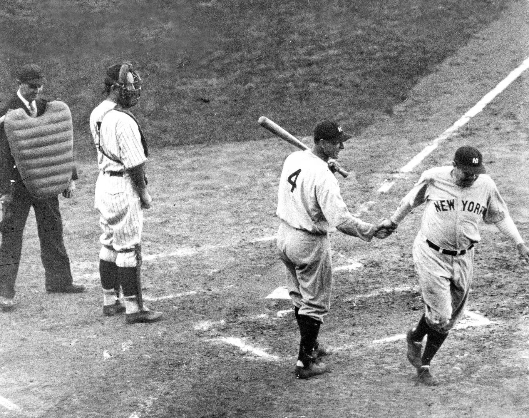Babe Ruth shakes hands with Lou Gehrig (4) at home plate.