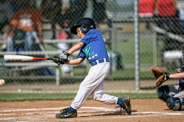 A Little League batter mid-swing