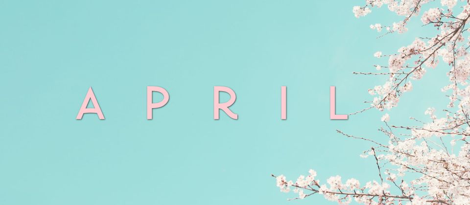 APRIL in pink text over blue sky with pale pink cherry blossom branches on right-hand side