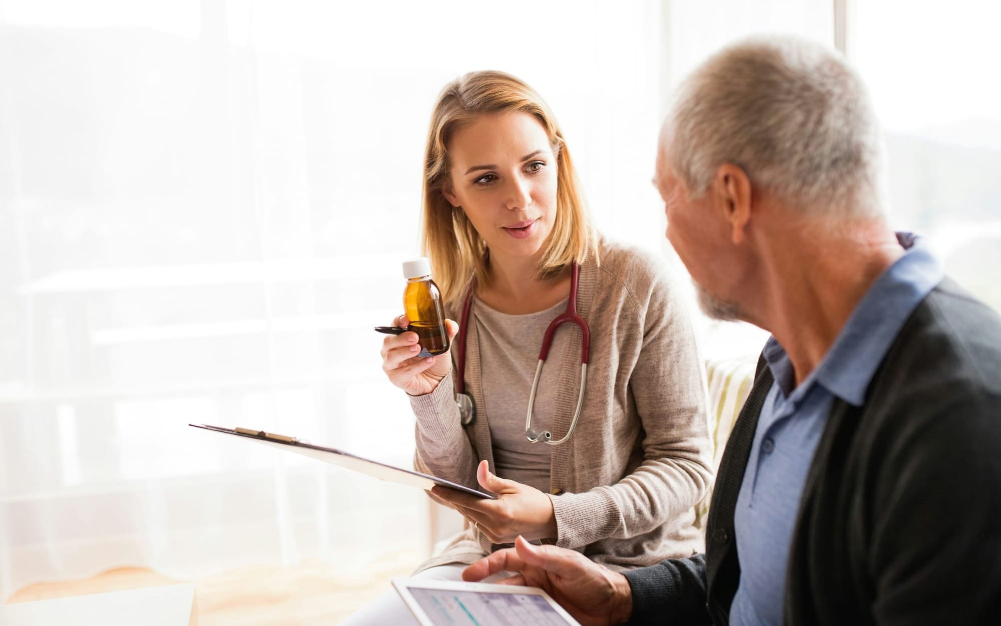 Clinician discussing treatment options with an older patient in natural light — a visual metaphor for reframing preventive metrics from lifespan to healthspan, emphasizing partnership and functional wellbeing.