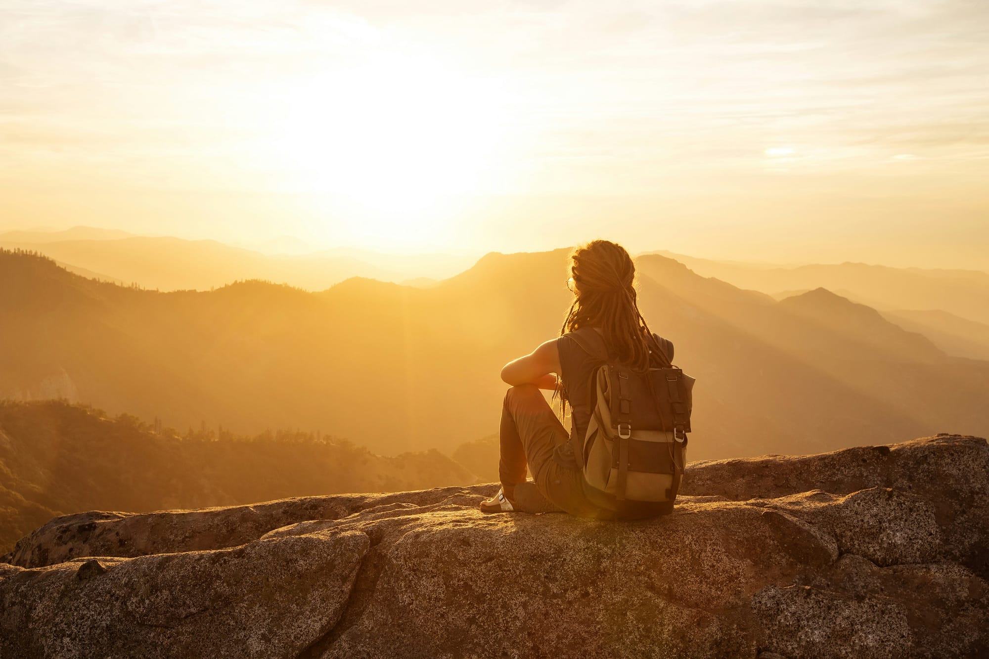 Person sitting in gentle sunrise light, symbolising the transition from cortisol dysregulation to restored circadian rhythm and biological balance.