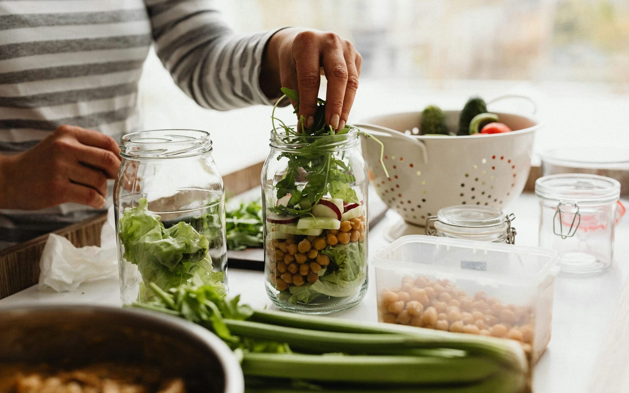 Woman preparing or enjoying a nutrient‑dense meal in natural light, symbolising Functional Medicine strategies that support HPA axis resilience and help make physiological stability the new normal.