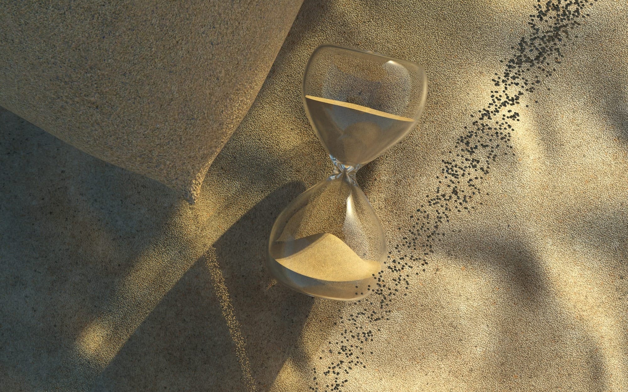 An abstract top-down view of a clear glass hourglass resting horizontally on textured sand with sharp, dramatic geometric shadows, symbolizing a stalled metabolism.