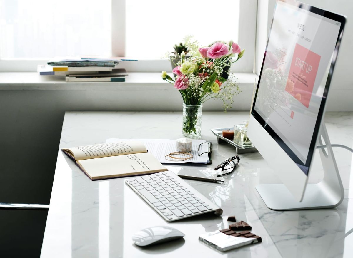 A bright, minimalist workspace with ivory and sage tones, natural light, and soft greenery.