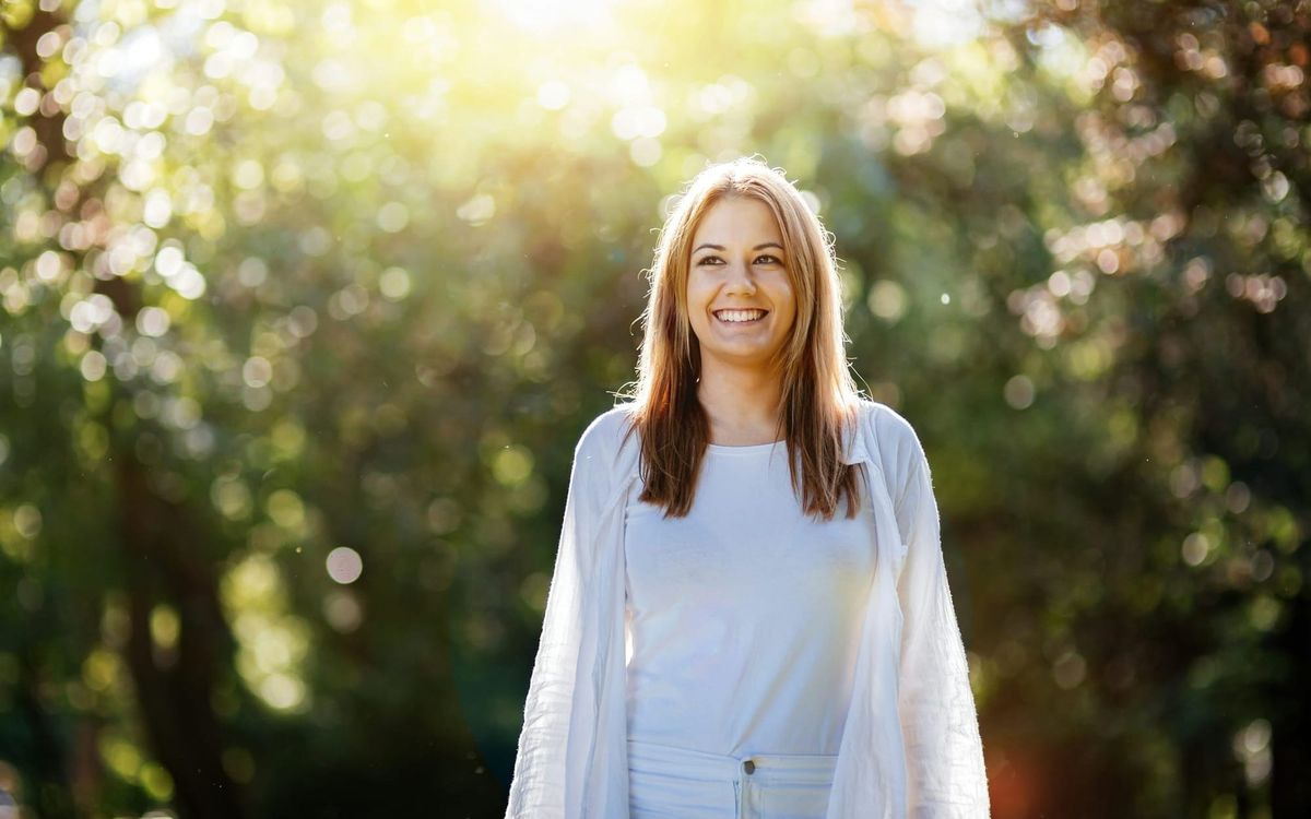Woman enjoying morning sunlight outdoors, symbolising natural cortisol rhythm reset and circadian balance.