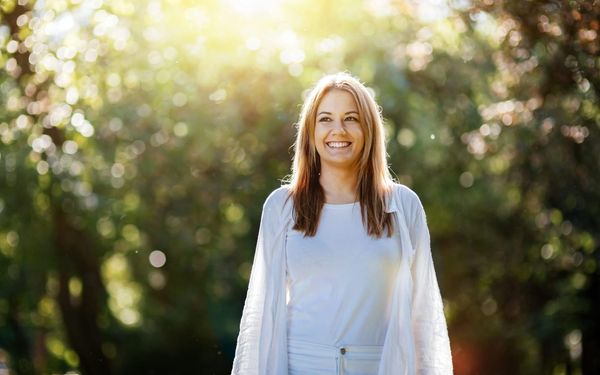Woman enjoying morning sunlight outdoors, symbolising natural cortisol rhythm reset and circadian balance.