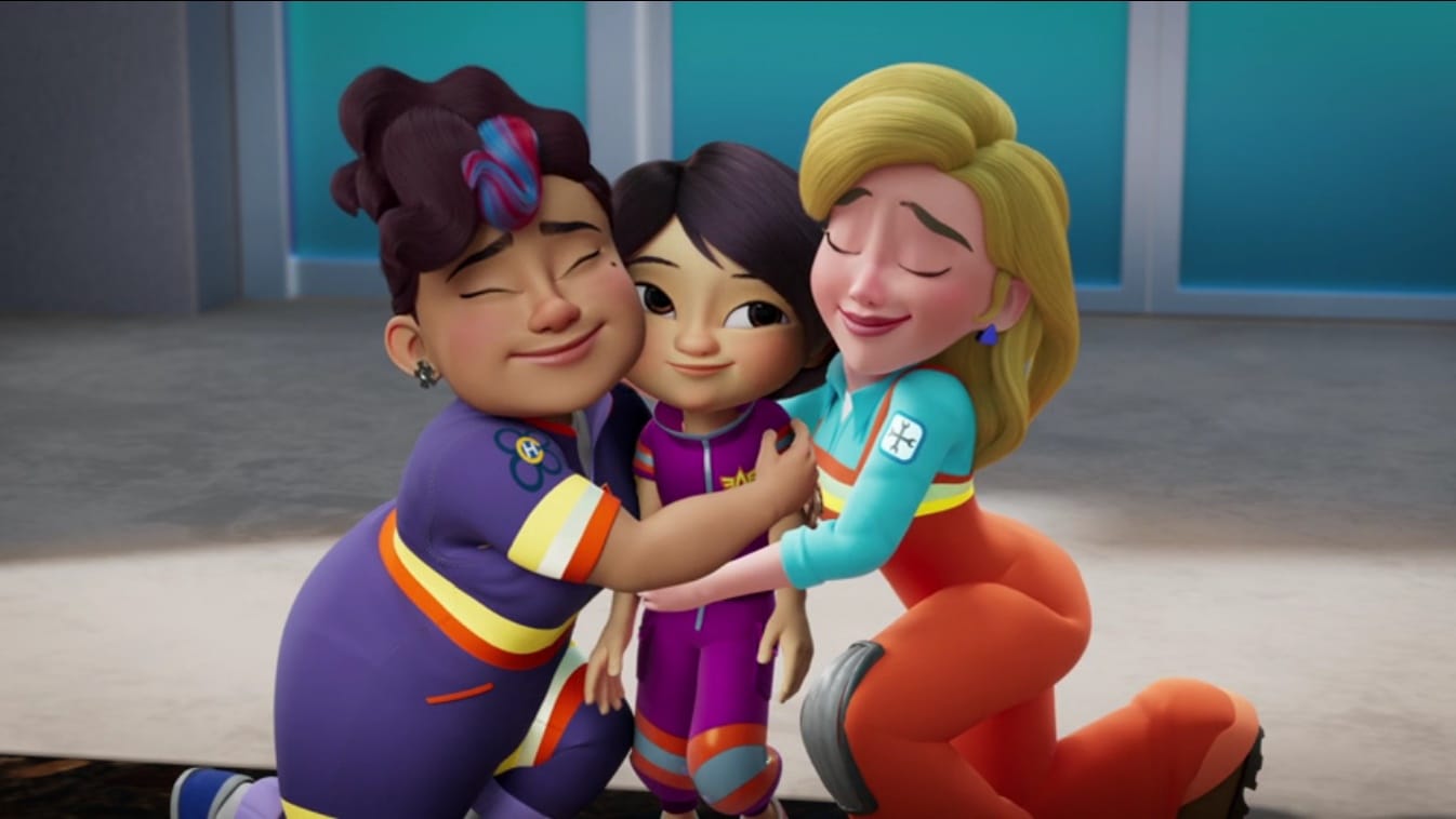 Violet, the girl Firebud, gets a hug from her two moms, who love her VERY MUCH, YES THEY DO.