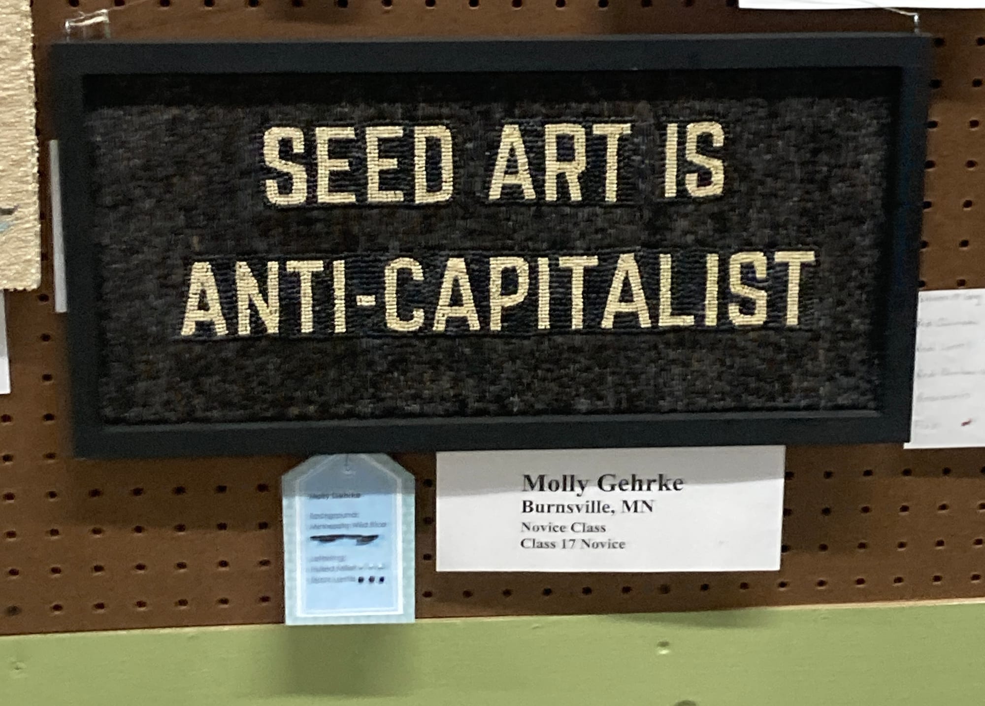 A seed art piece that reads "Seed Art Is Anti-capitalist." It's made by someone named Molly Gehrke.