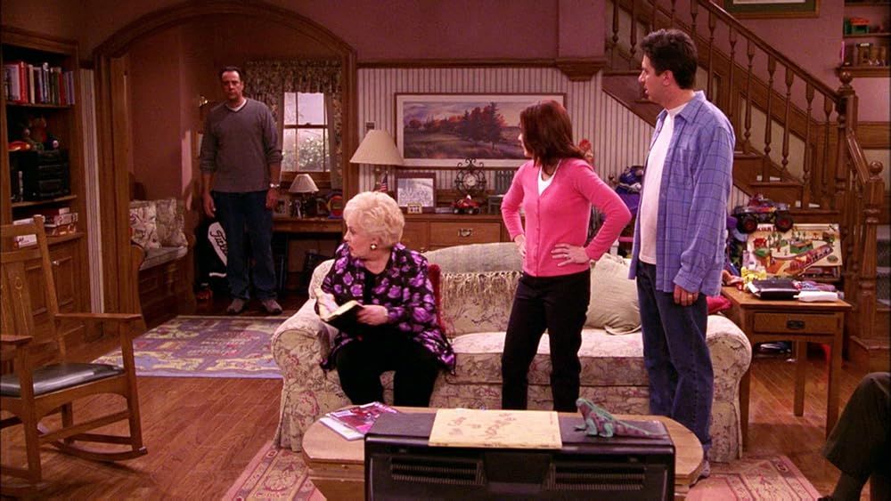 Marie (sitting, holding Bible), Debra (standing, in pink), and Ray (standing, in blue) look back at Robert, who lurks in the corner, clearly distresse
