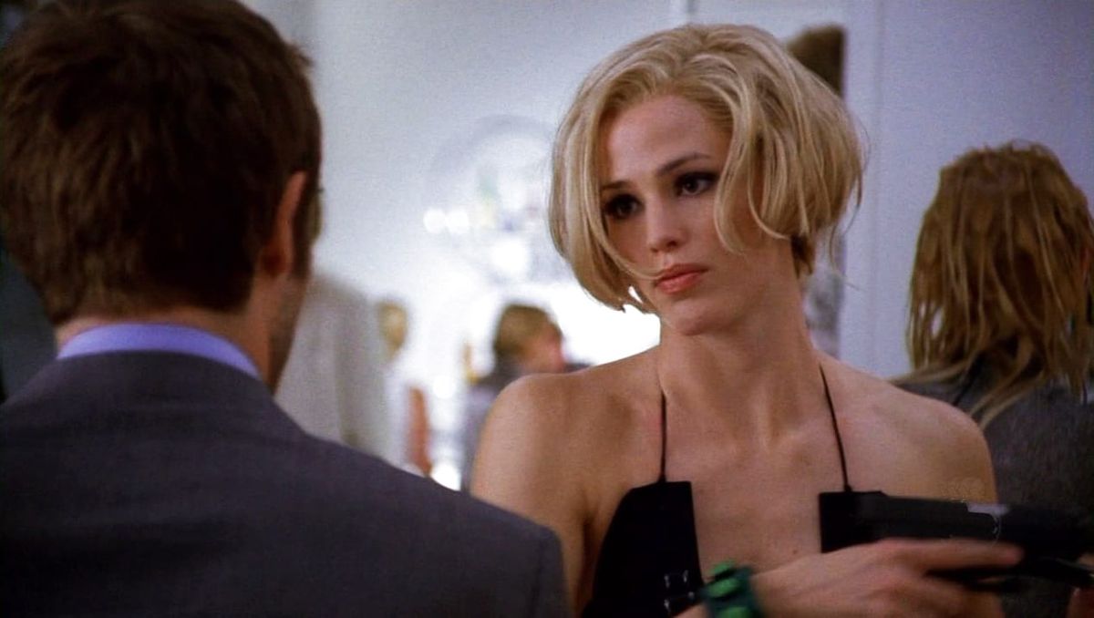 Jennifer Garner, in a blonde wig and a thinly strapped dress, makes bedroom eyes at a man whose back we see. (It's Vaughn.)