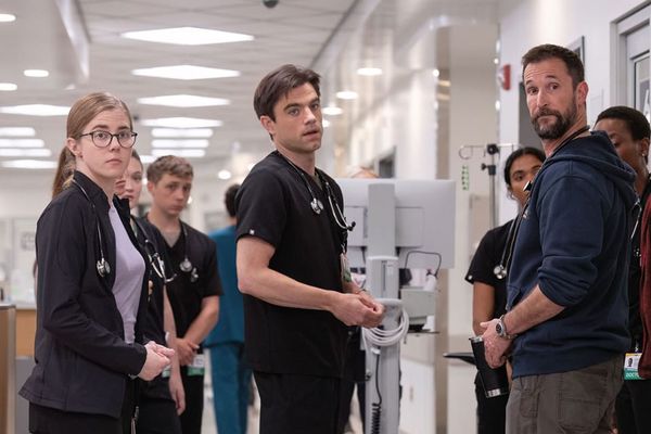 Several doctors of The Pitt look just off-camera with concern at a patient who is just entering.