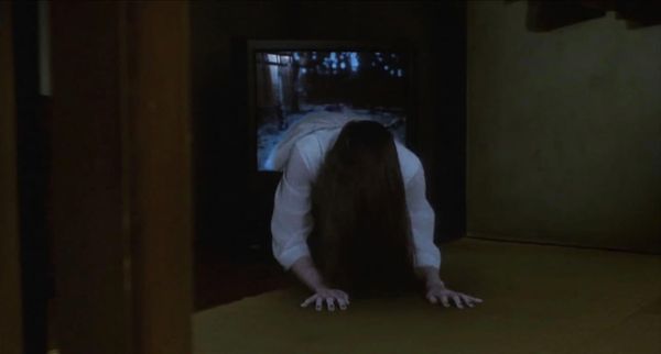A girl crawls out of a television, long dark hair draped down so you cannot see her face.