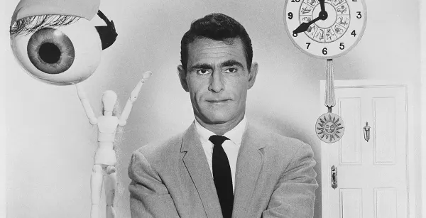 Rod Serling grimaces warily at you as he stands with many odd icons of the uncanny, including an eyeball and a clock. 