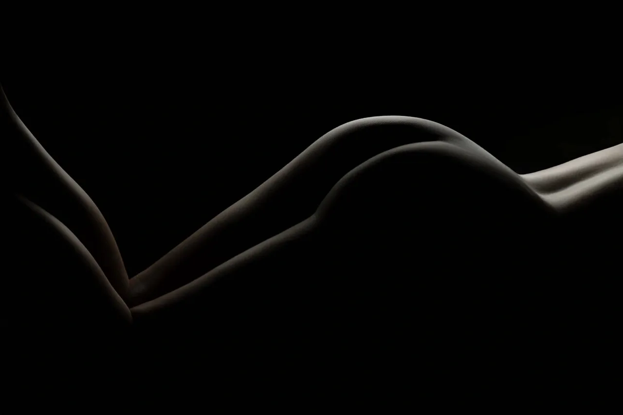 Creative nude photography with coffee used as a playful prop on bare skin.