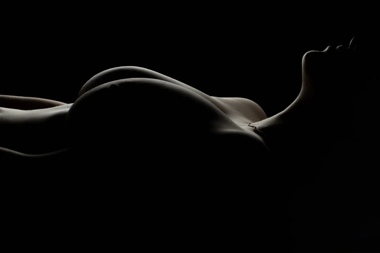 Bold and sensual bodyscape with color-enhanced skin and minimalist background.