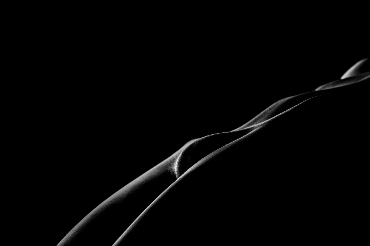 Bodyscape nude photo with dramatic highlights and shadow curves resembling desert dunes