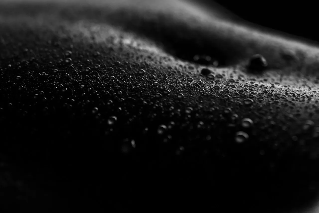 Close detail of water droplets on skin creating abstract bodyscape textures