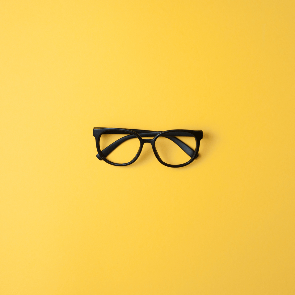 A person wearing blue light glasses and looking at a computer screen