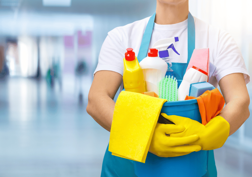 A person wearing blue light glasses and cleaning them with a microfiber cloth