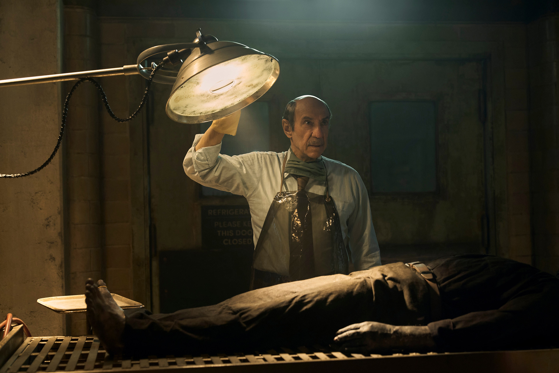 Still from CABINET OF CURIOSITIES episode THE AUTOPSY with F. Murray Abraham standing over a cadaver.