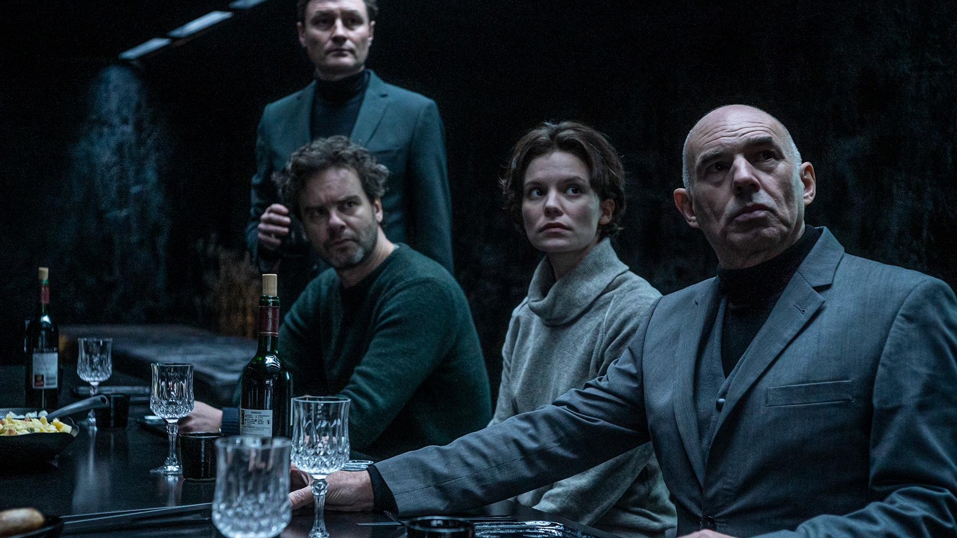 Film still from NR. 10 with characters at a dinner table looking off-screen.