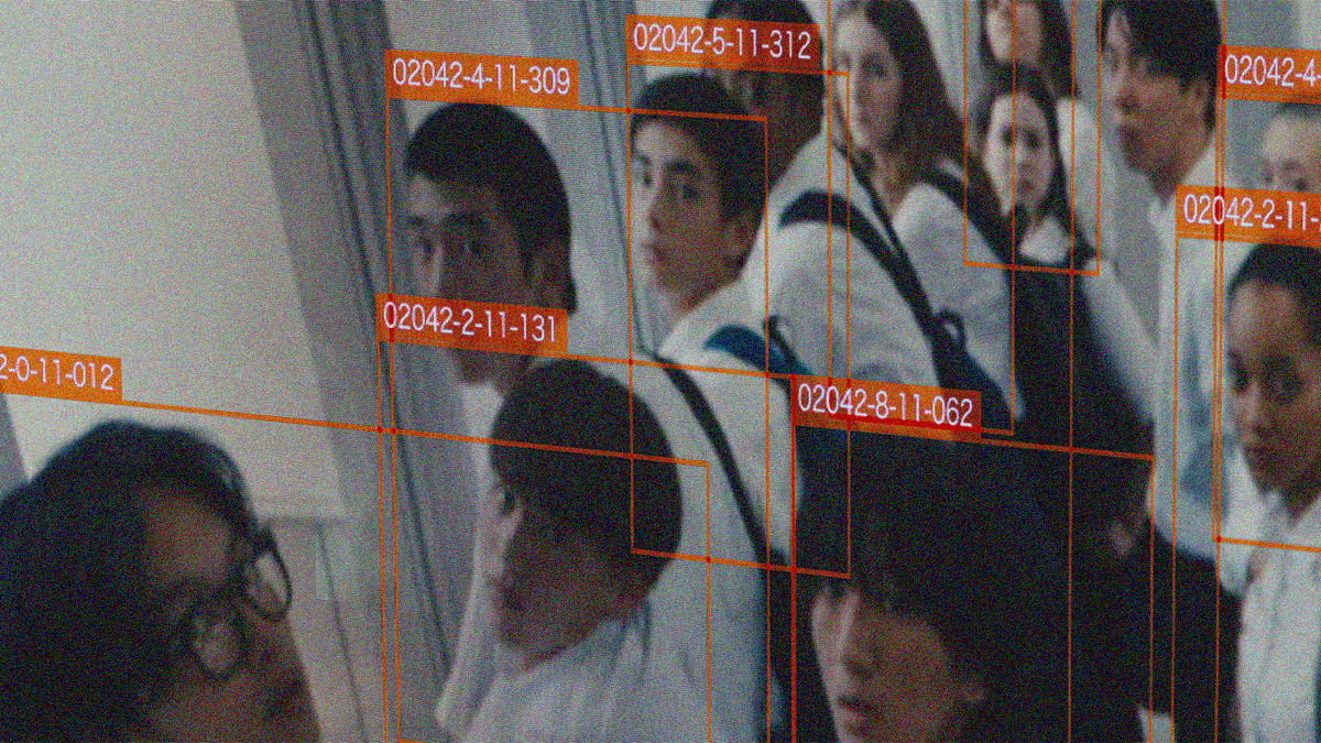 An angled surveillance screen shot of high school students with red boxes around their faces and numbers presumably signifying their identities.