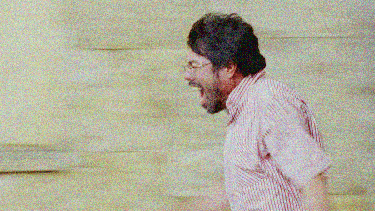 A man in profile facing left screaming.