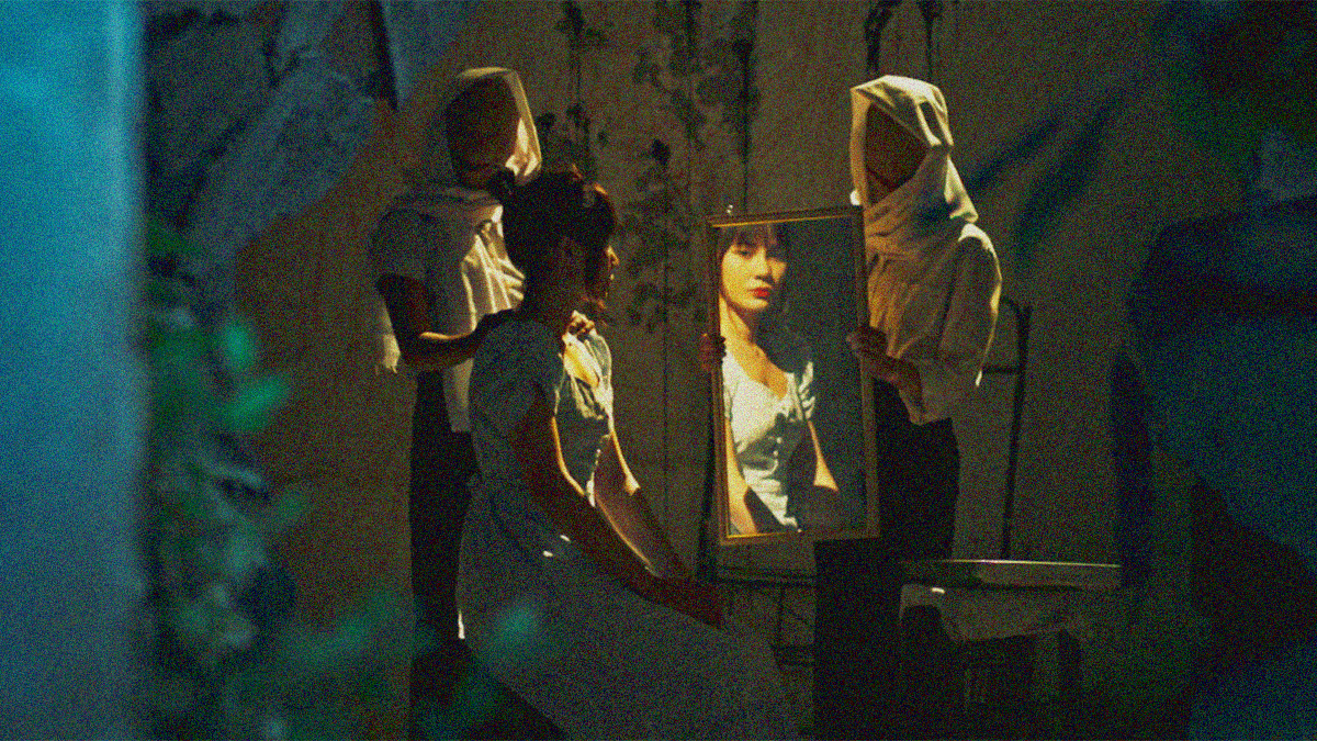 A seated woman with back to us is seen through her reflection in a mirror held by a masked and scarved woman in white. Another woman in white stands behind her.
