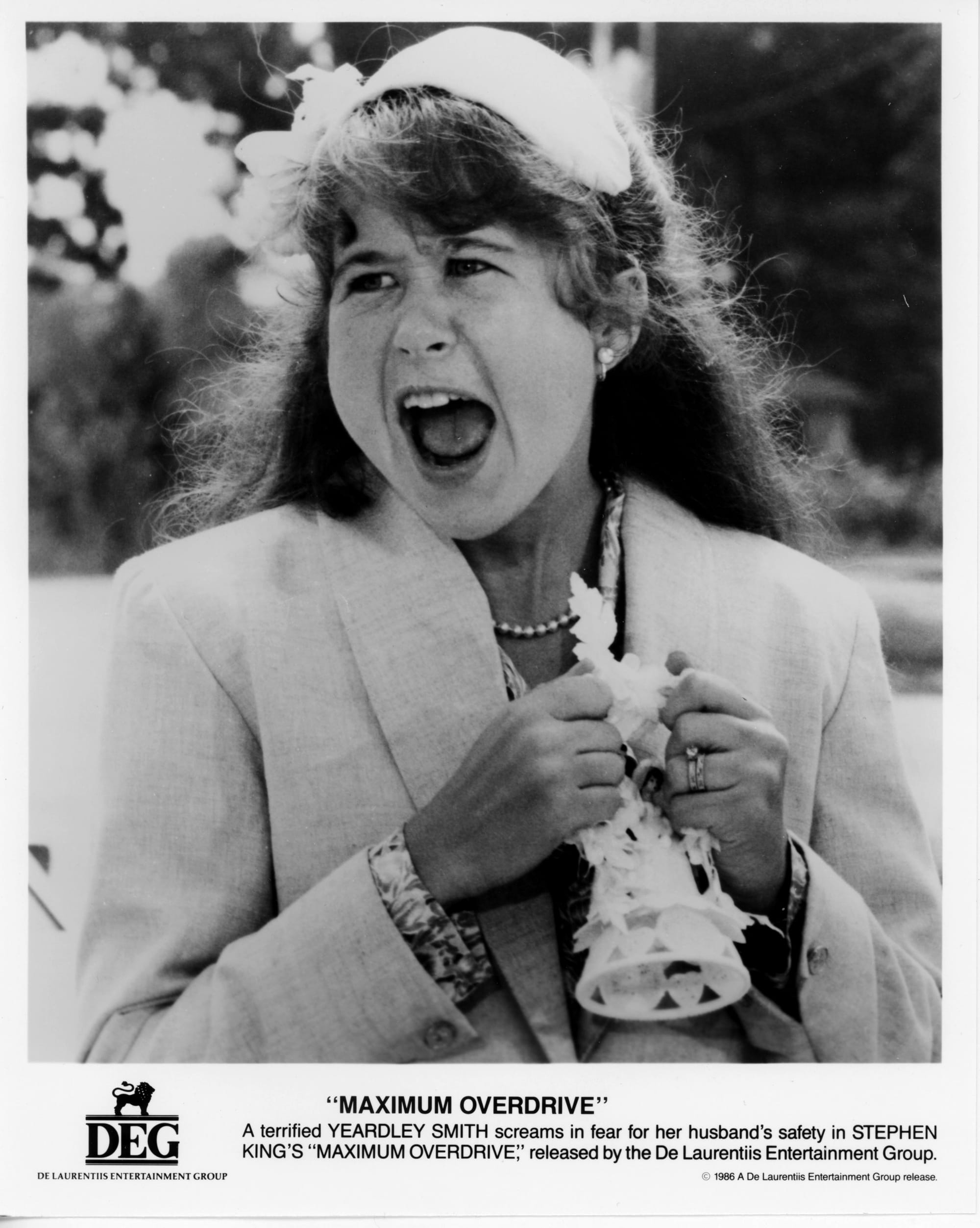 B&W Publicity Photo: Yeardley screams in a suit jacket while clutching a cone shaped object in her hands.