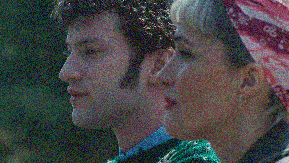 Close-up in profile of a woman (foreground) and man (background) silently looking left.