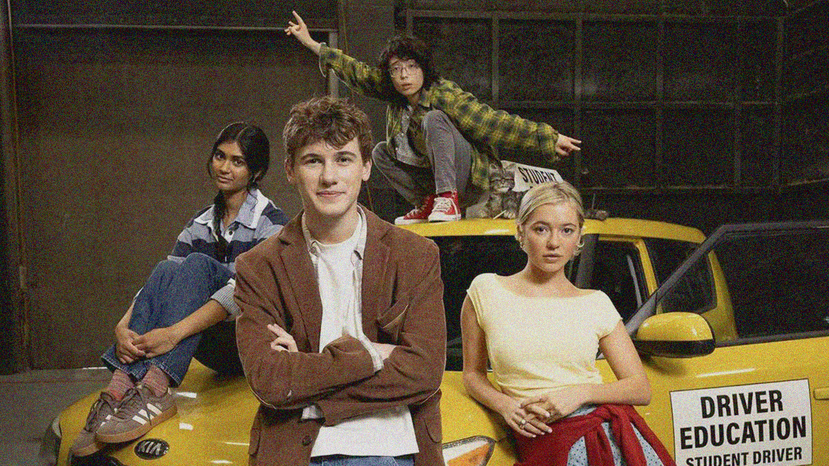 Four teens surrounding a yellow "Student Driver" car. The main boy is leaning at front of hood. A girl is leaning behind him. Another girl sits on hood. Another boy crouches on the roof.